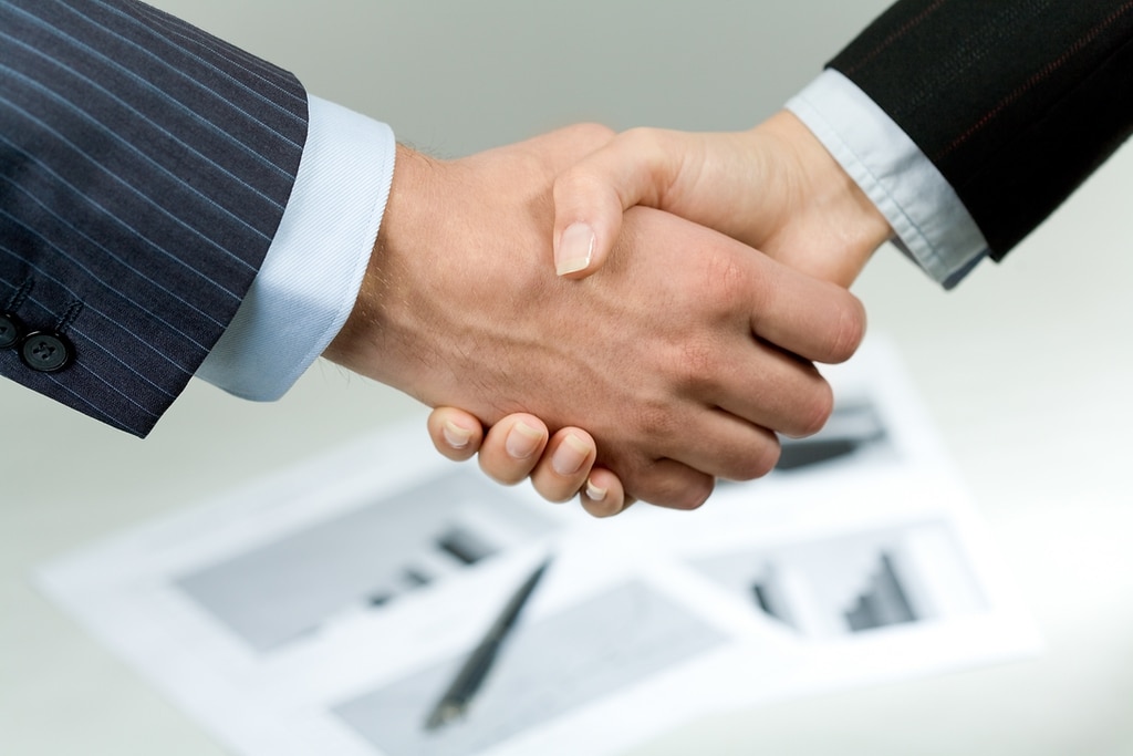 Deux directeurs commerciaux se serrent la main suite à une formation en leadership